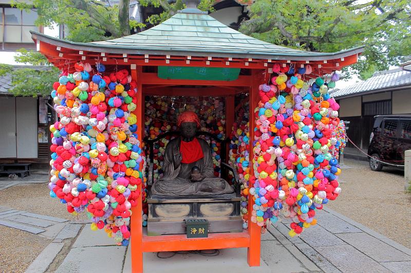japan0544.JPG - Yasaka Koshindo Temple, a seated figure inside and the surrounding walls covered in Kukurizaru