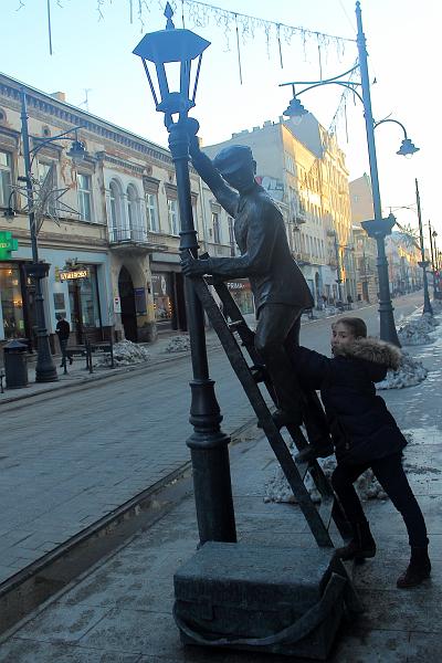 poland173.JPG - Alyssa helps to a lamp lighter on Piotrkowska Street, Lodz